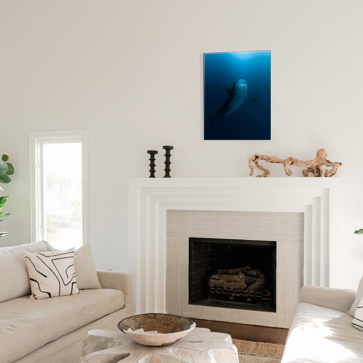 Living room with a fireplace and a glass print of a shark swimming upward above it