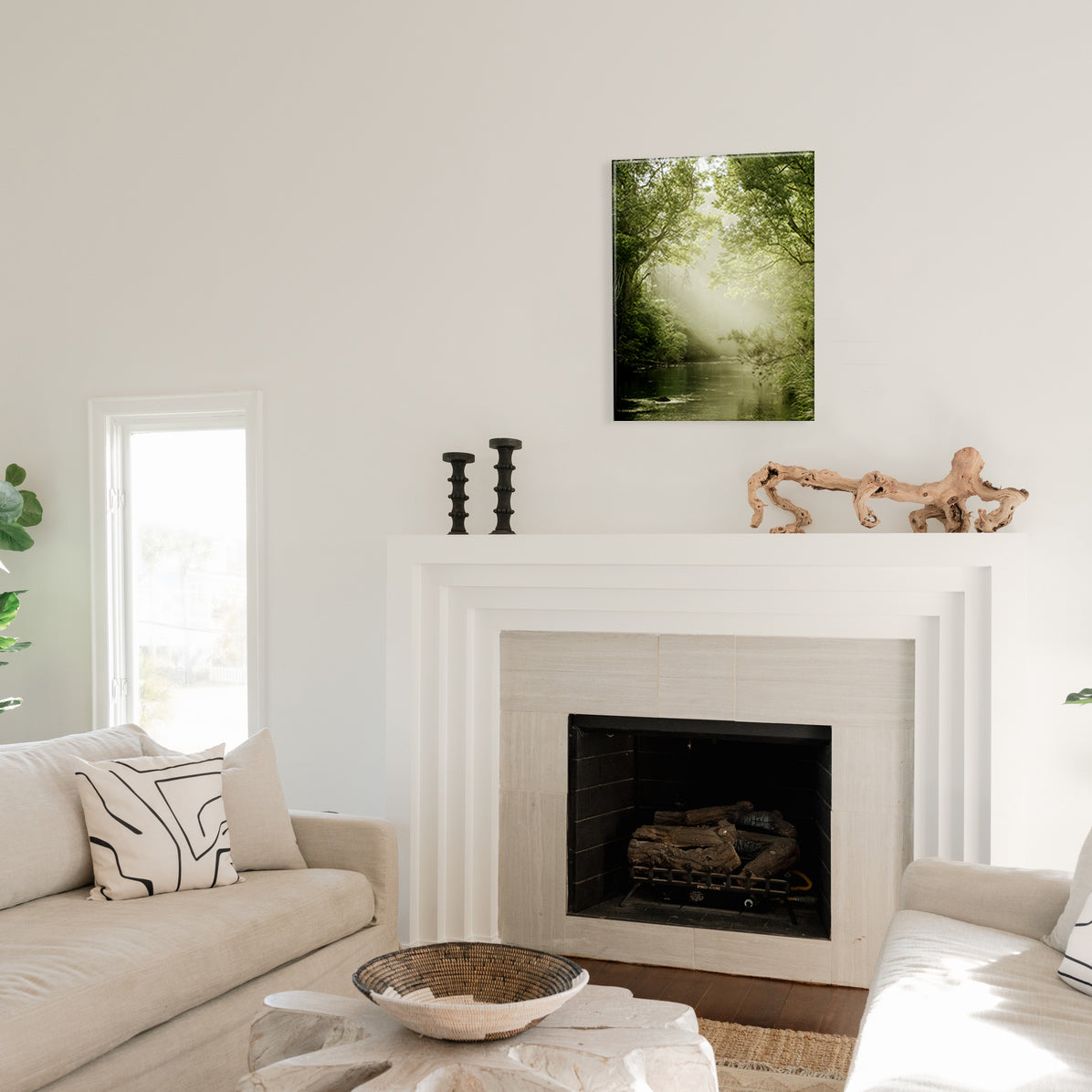 Living room with a fireplace, decorative items, and a nature-themed glass print.