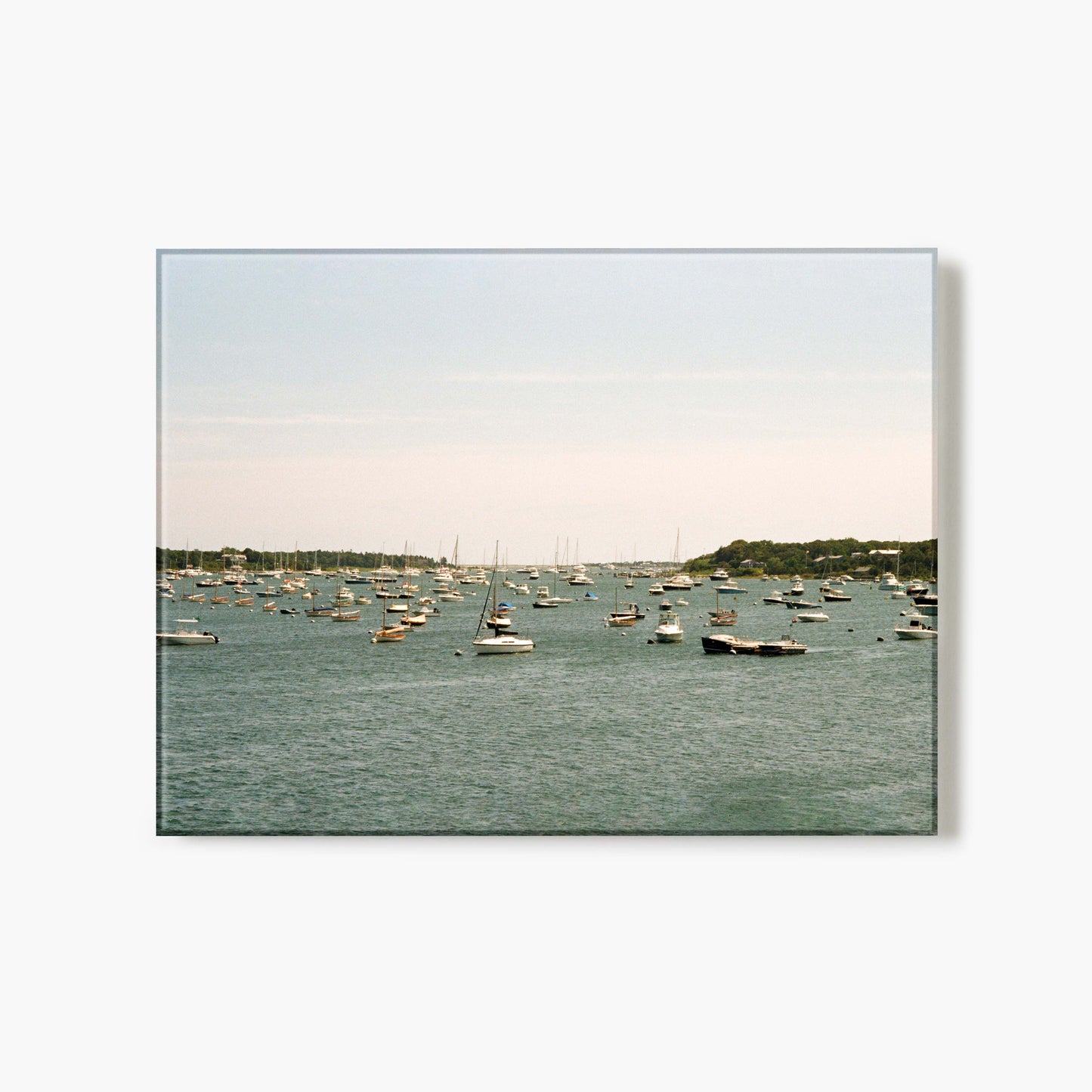 A glass print of a harbor with boats on a calm day