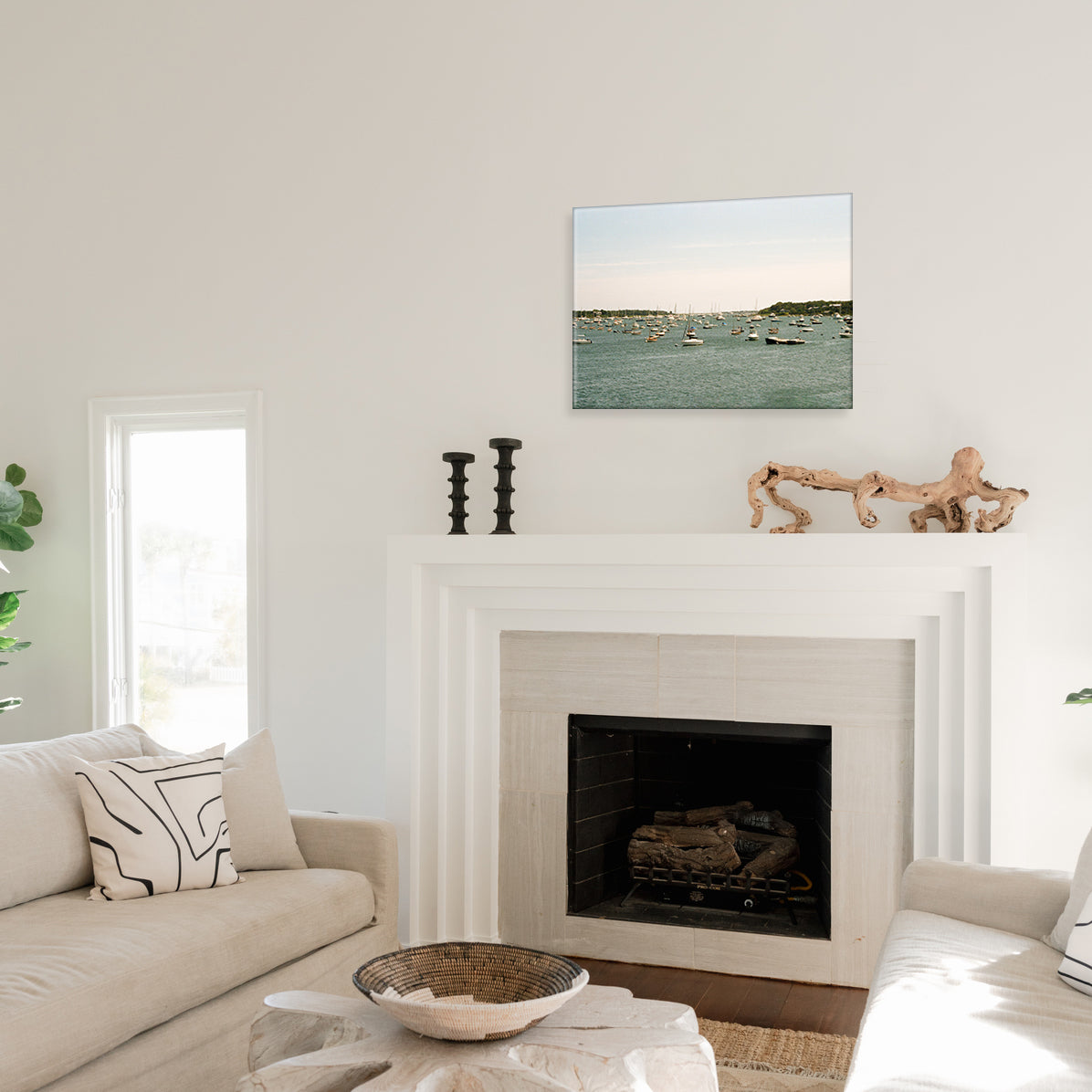 Living room with a fireplace, couch, and a glass print of a harbor scene.