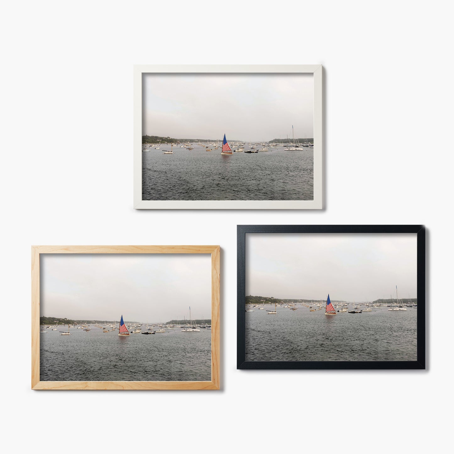 Three framed glass prints of a harbor scene with sailboats on a white background.