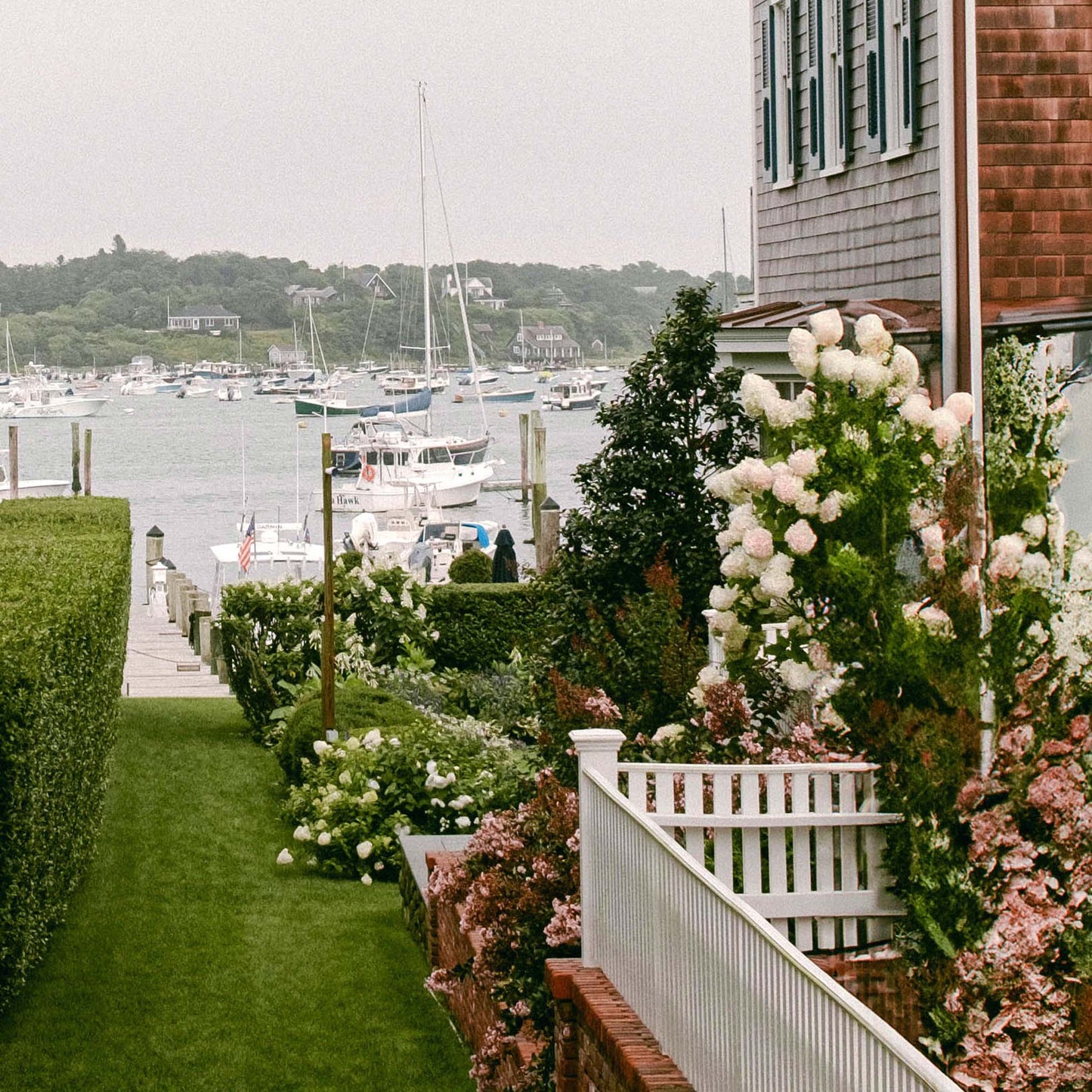 Close up of a marina view from a residential area with flowers and a house.
