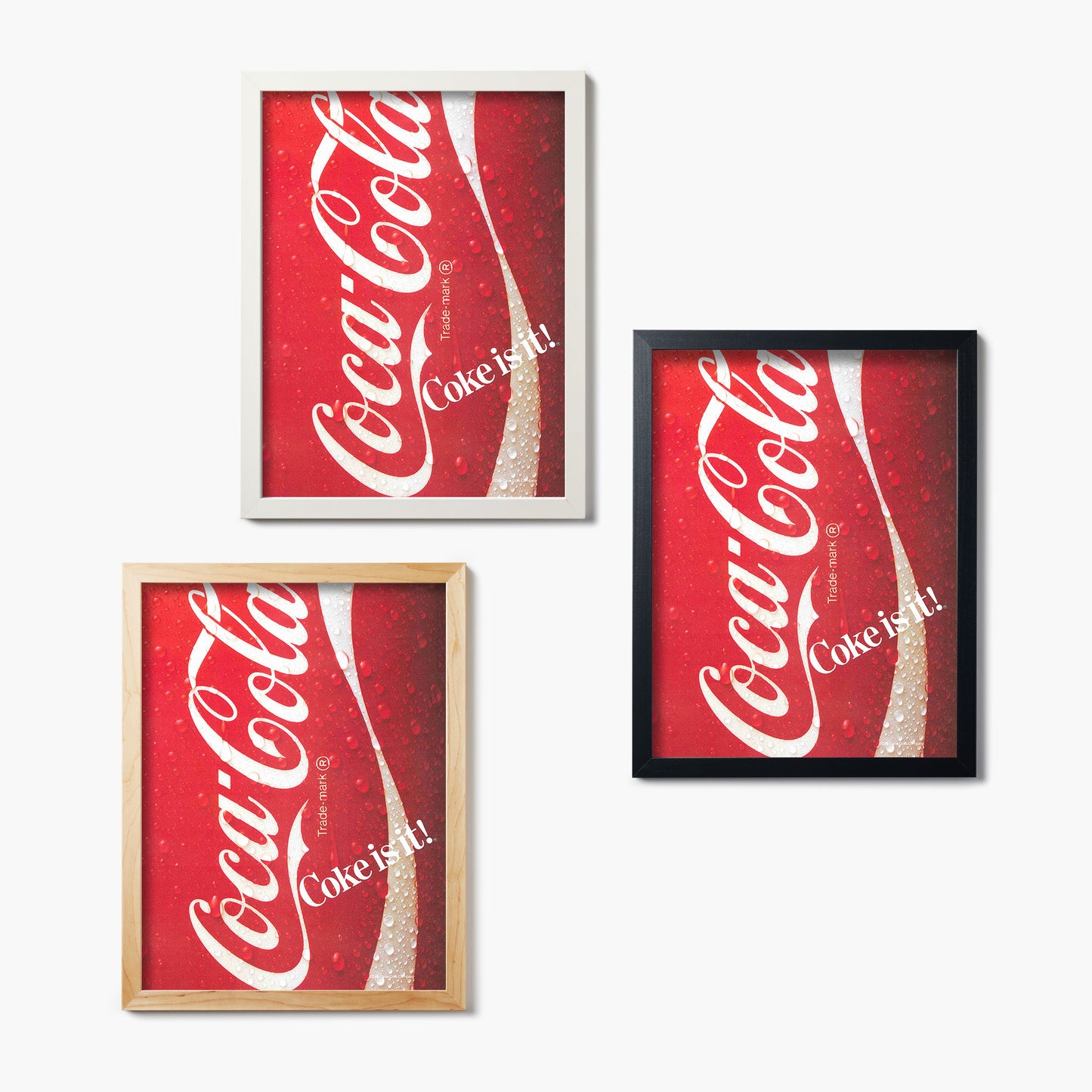 Three Coca-Cola-themed glass prints in different frames on a white background