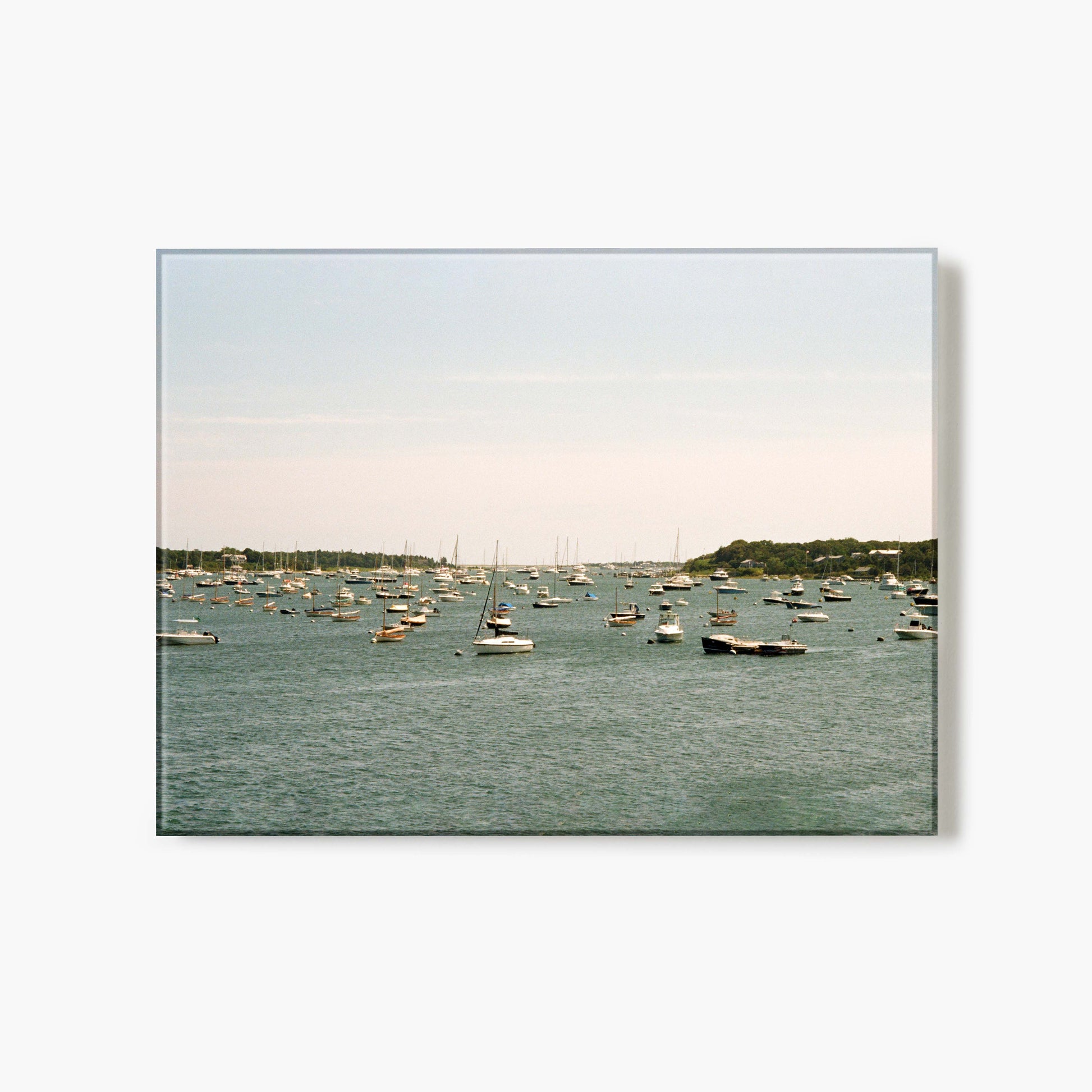 A glass print of a harbor with boats on a calm day