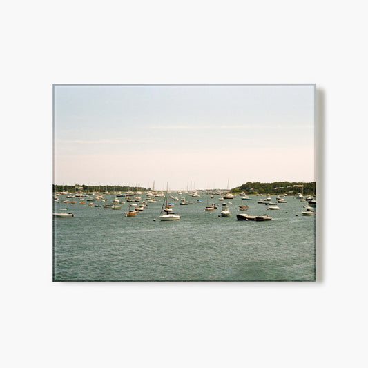 A glass print of a harbor with boats on a calm day