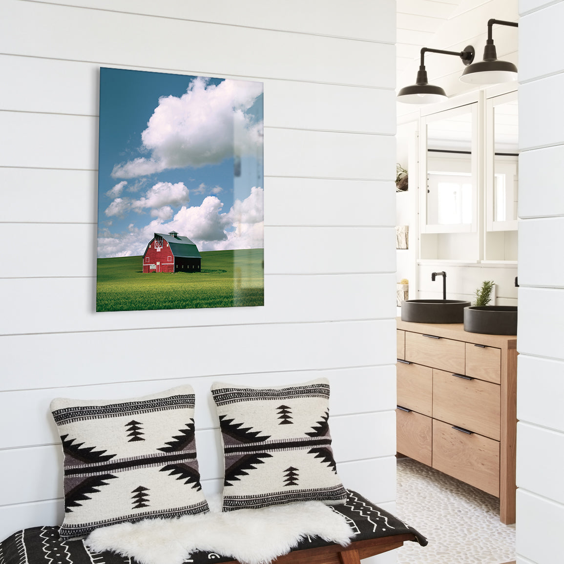 White wood paneled walls with a large glass print of a red barn.