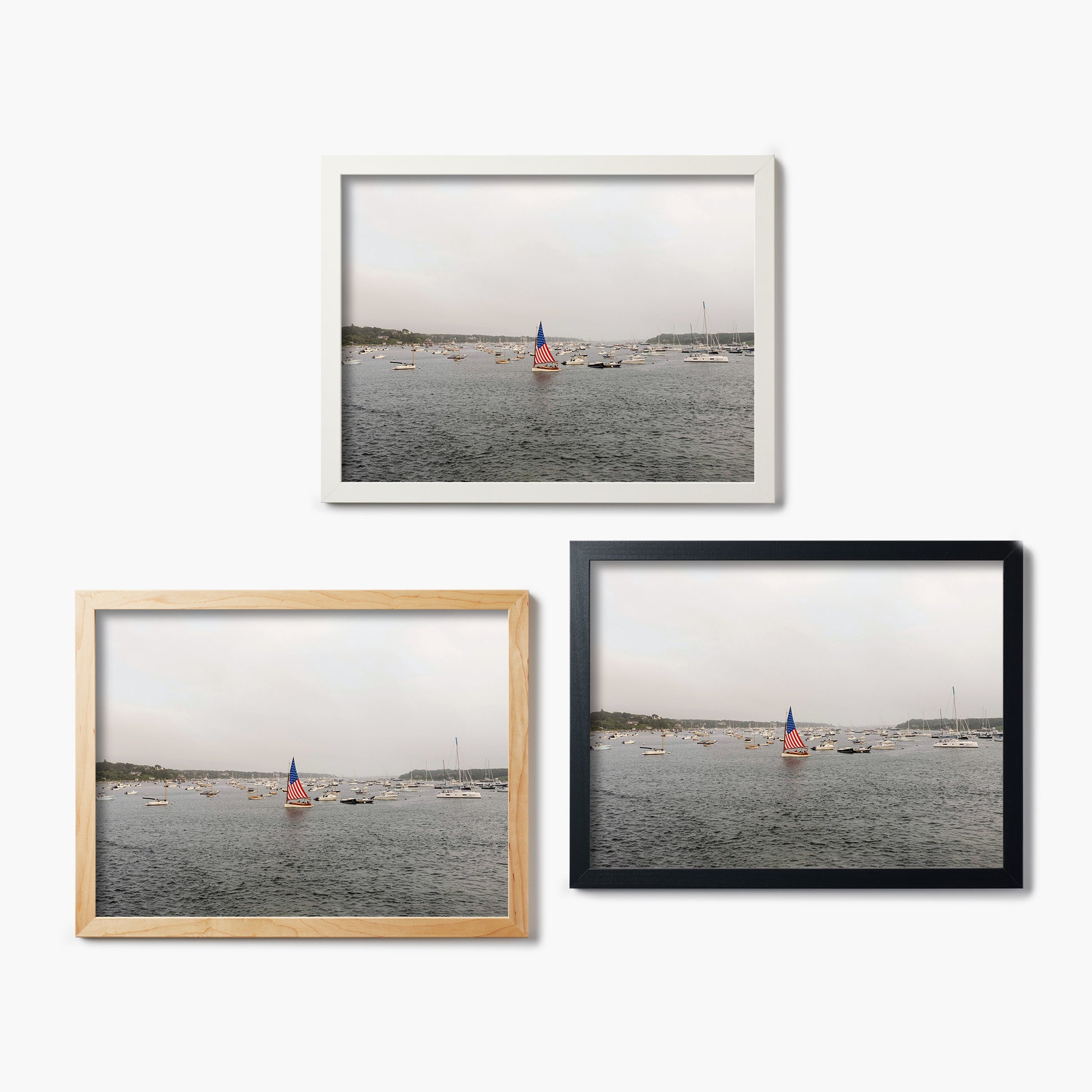 Three framed glass prints of a harbor scene with sailboats on a white background.