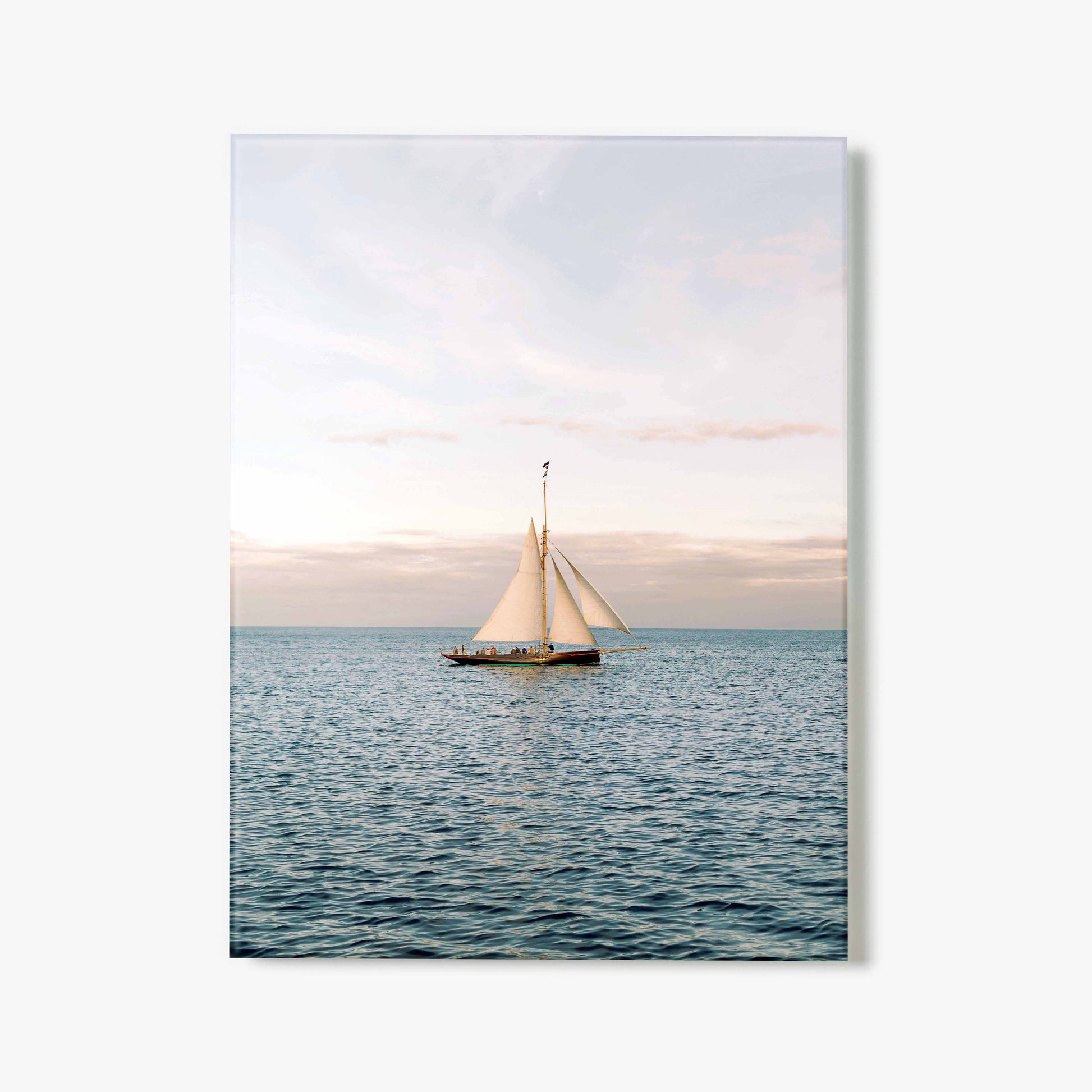 Glass print of a sailboat on the water with a pastel sky