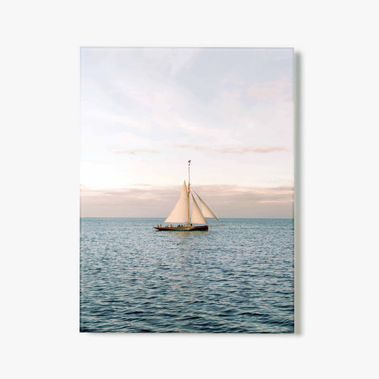 Glass print of a sailboat on the water with a pastel sky